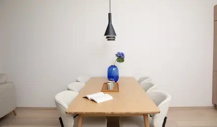a table with chairs and a vase of flowers
