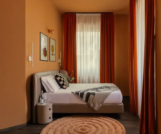 a bed in a room with orange curtains
