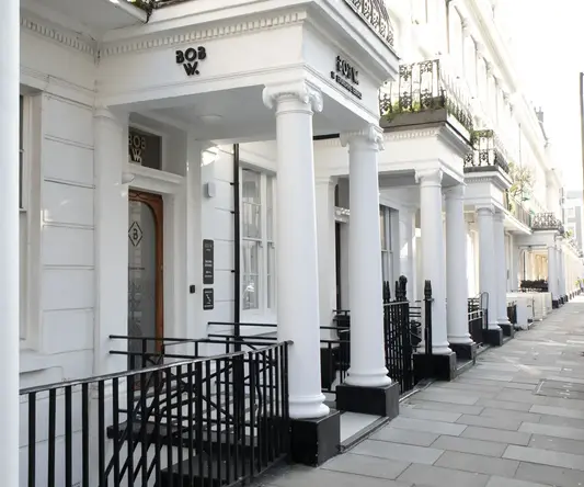 a white building with columns and a railing