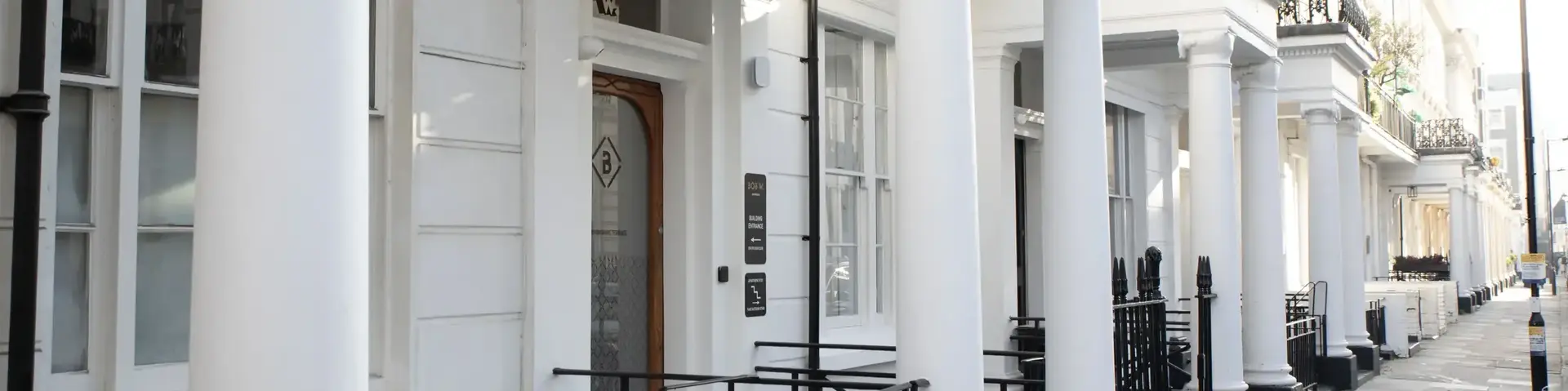 a white building with columns and a railing
