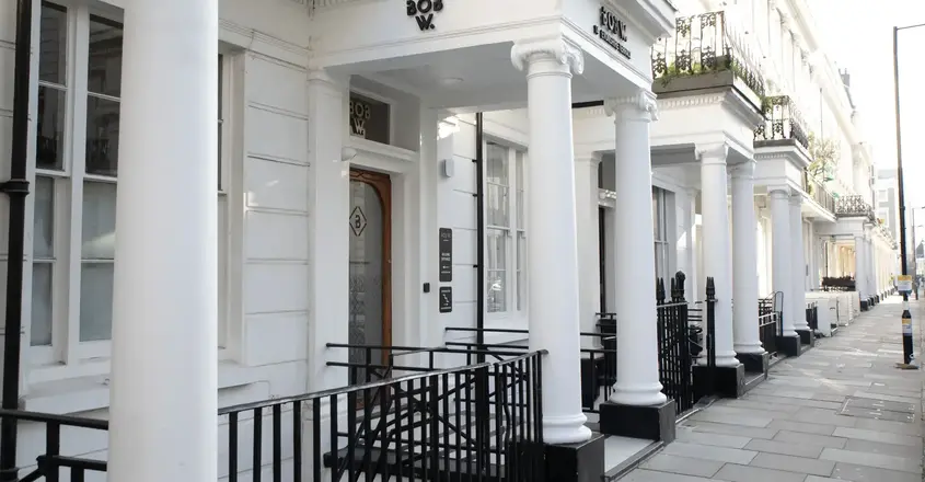 a white building with columns and a railing