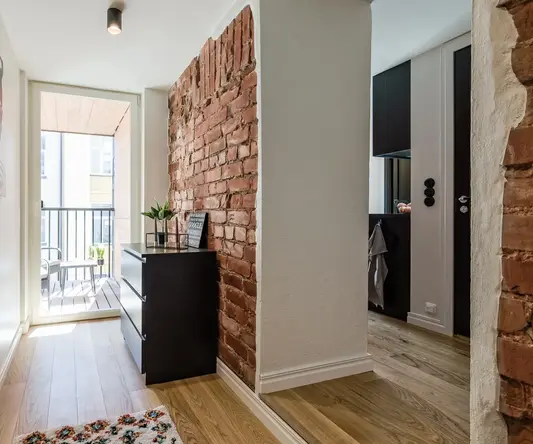 a hallway with a brick wall and a mirror