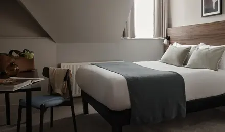 a bed with a chair and a desk in a room