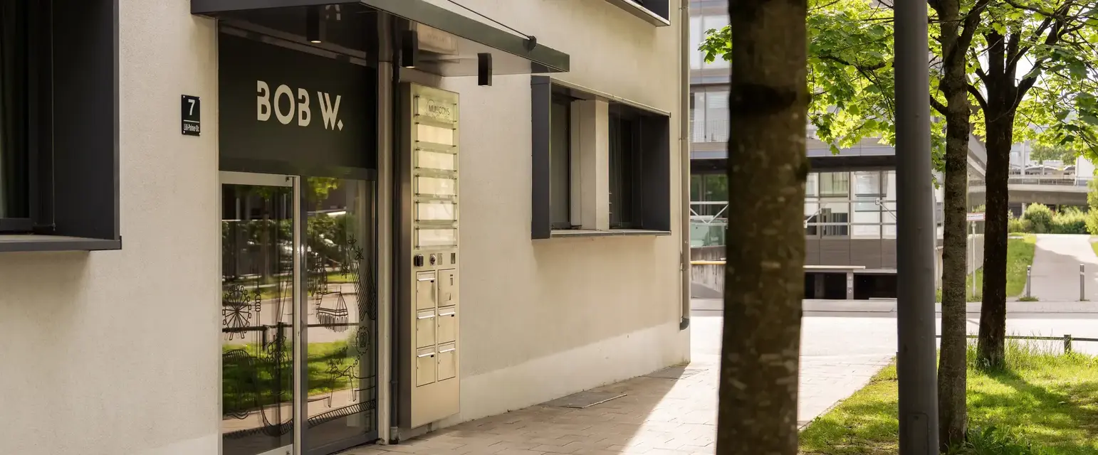 a building with a tree and a sign