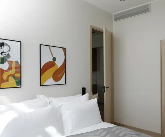 a bed with pillows and a painting on the wall