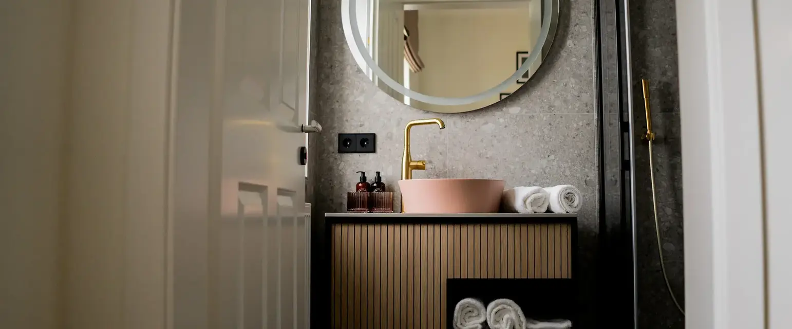 a bathroom with a round mirror and sink