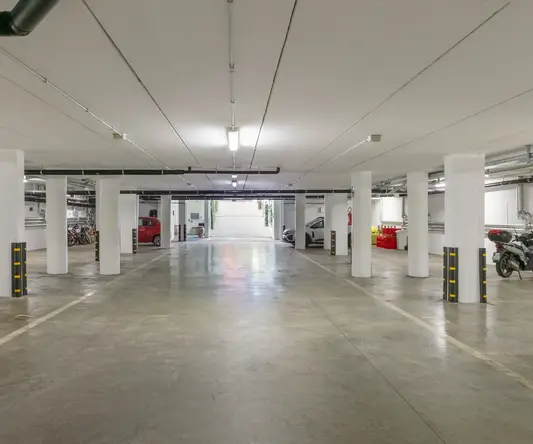 a large parking garage with white pillars