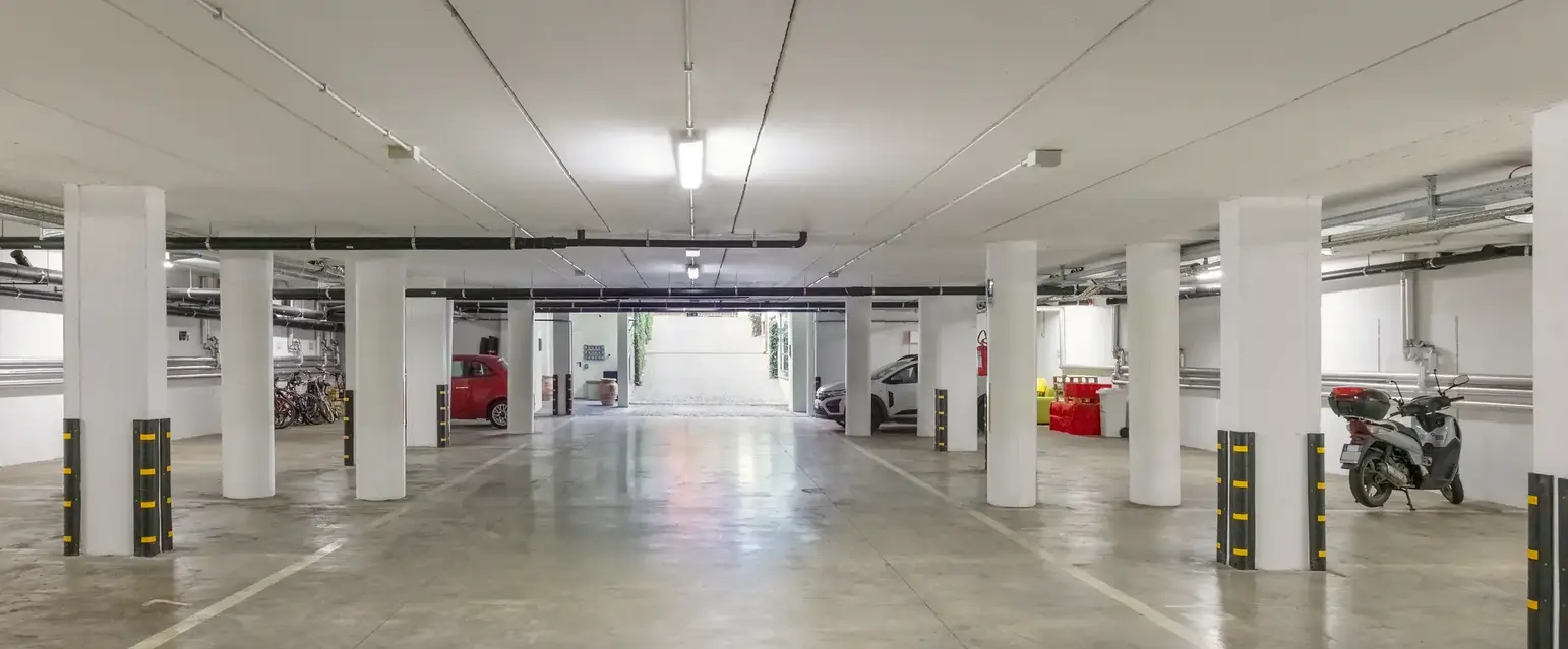 a large parking garage with white pillars