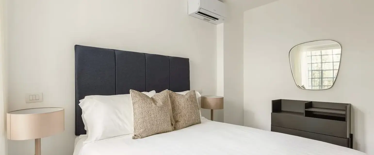 a bed with pillows and a mirror in a room