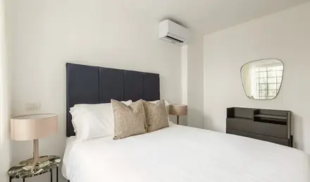 a bed with pillows and a mirror in a room