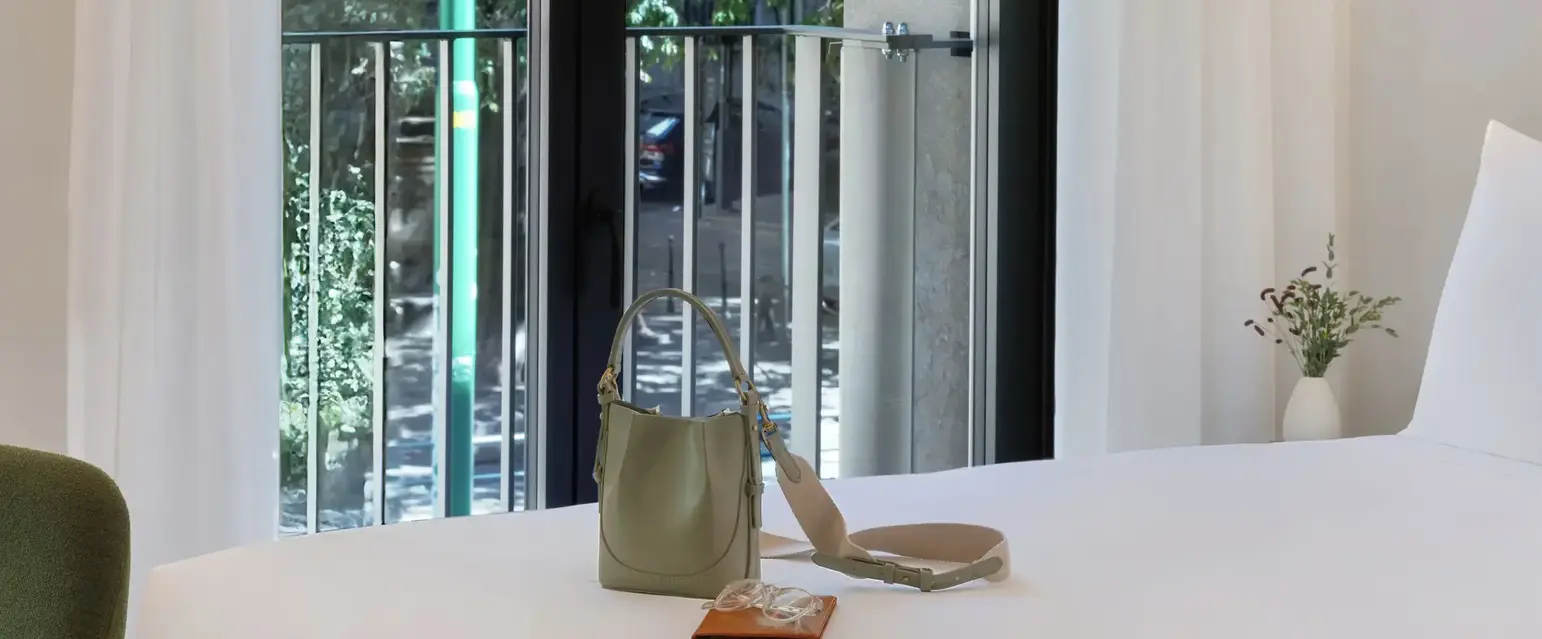 a bed with a white sheet and a purse on it