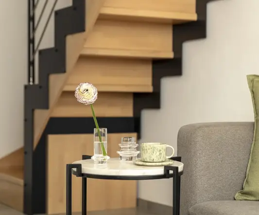 a coffee cup and saucer on a table in front of a staircase