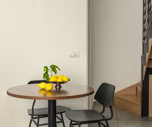 a table with chairs and a bowl of lemons on it