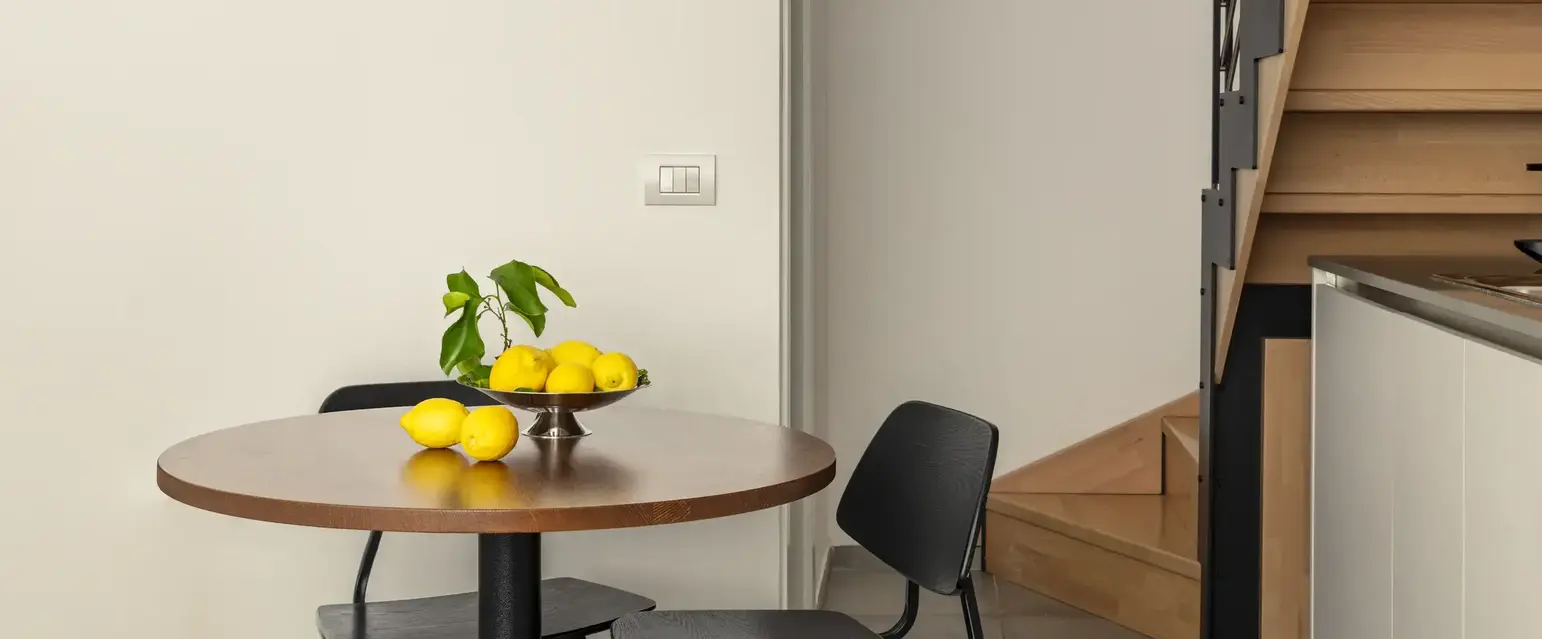 a table with chairs and a bowl of lemons on it