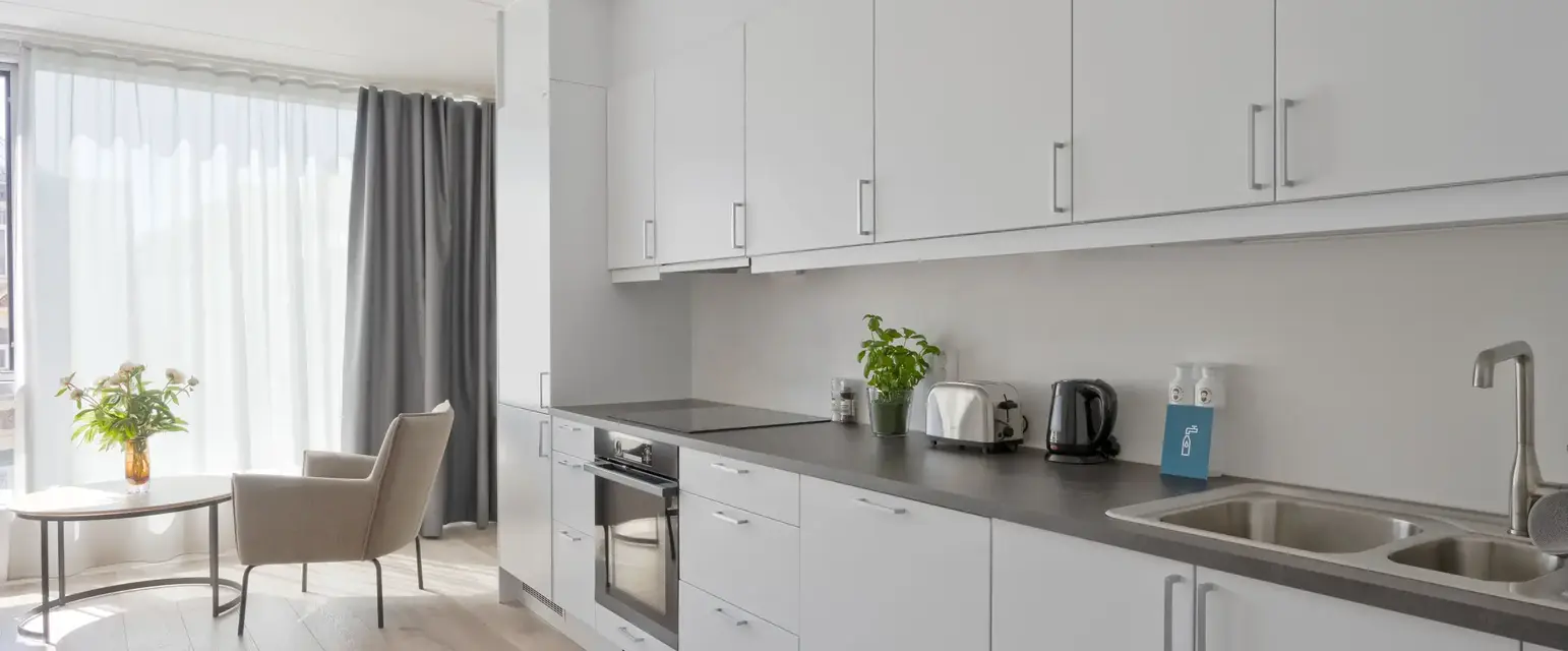 a kitchen with white cabinets and a wood floor