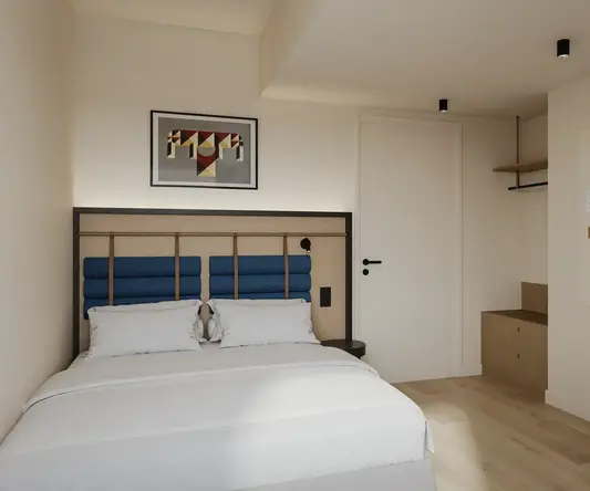 a bedroom with a bed and a picture on the wall