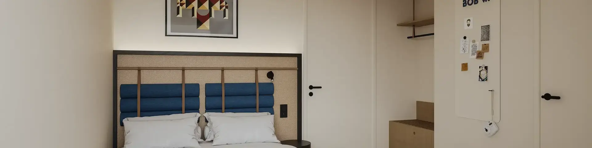 a bedroom with a bed and a picture on the wall
