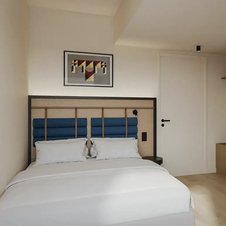a bedroom with a bed and a picture on the wall