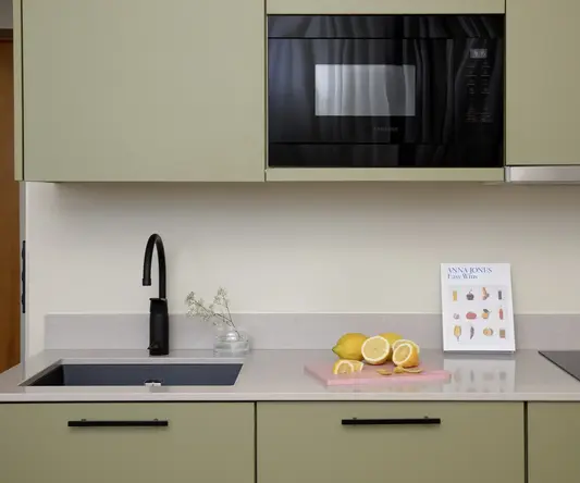 a kitchen with a microwave and a black sink