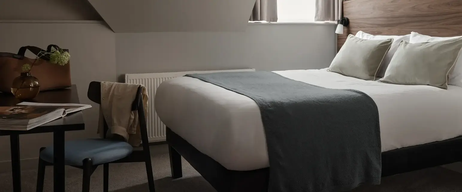 a bed with a chair and a desk in a room