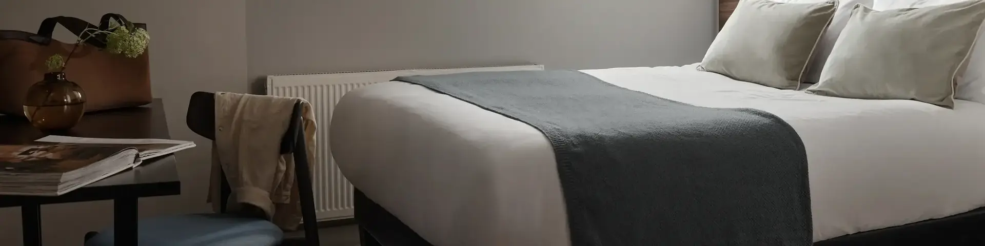 a bed with a chair and a desk in a room