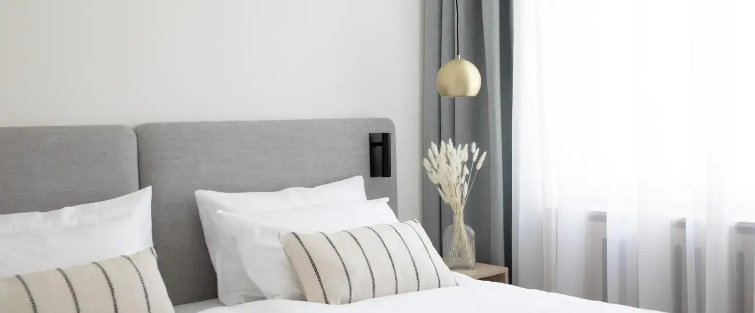 a bed with white sheets and pillows