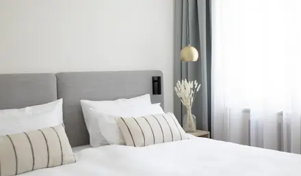 a bed with white sheets and pillows