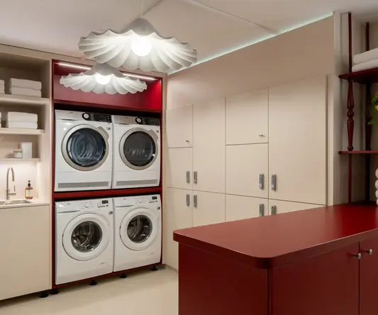 a laundry room with red cabinets and white appliances