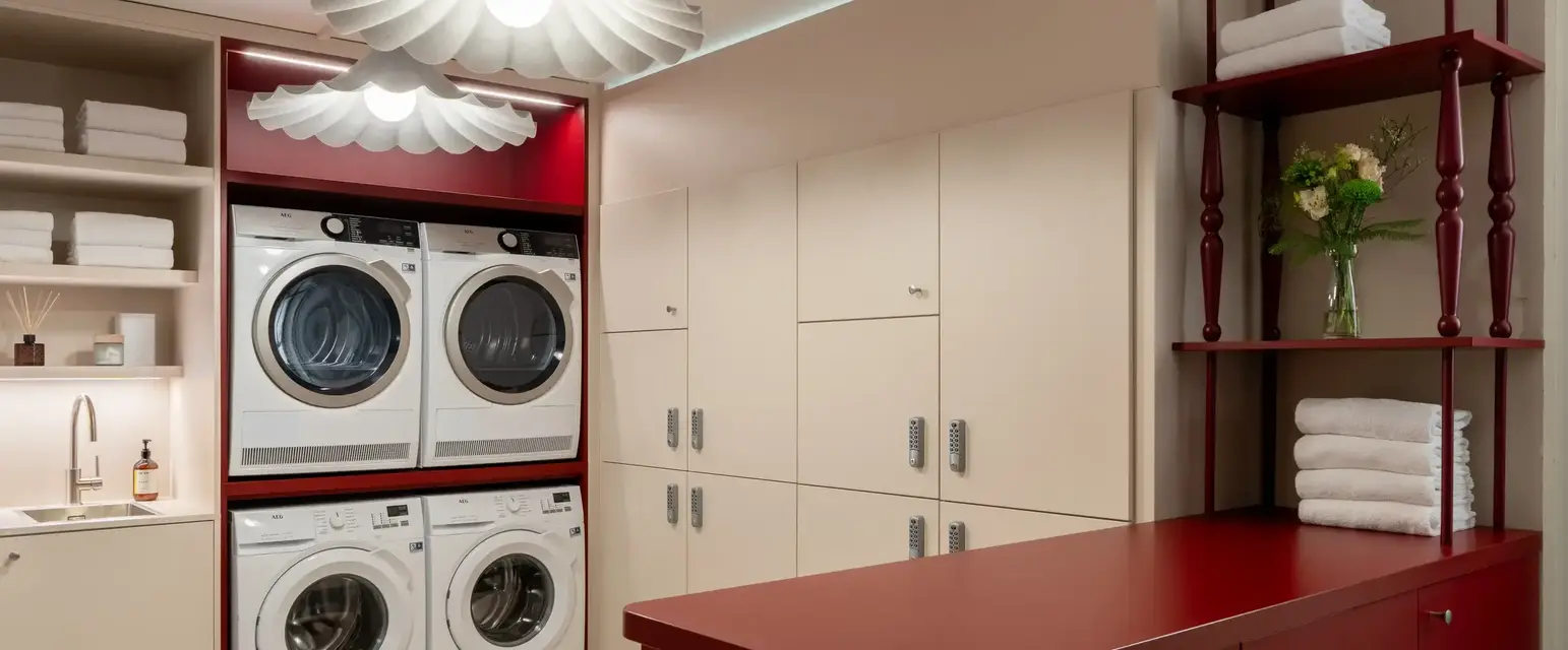 a laundry room with red cabinets and white appliances