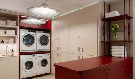 a laundry room with red cabinets and white appliances