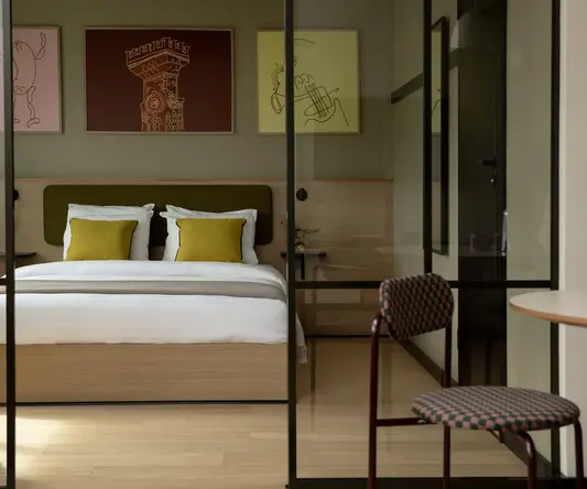 a bed with pillows and a chair in a room