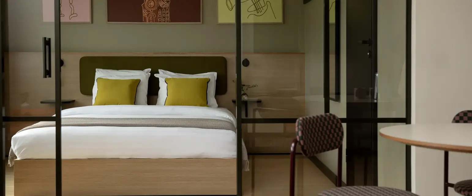 a bed with pillows and a chair in a room