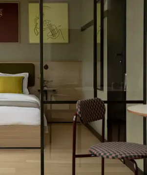 a bed with pillows and a chair in a room