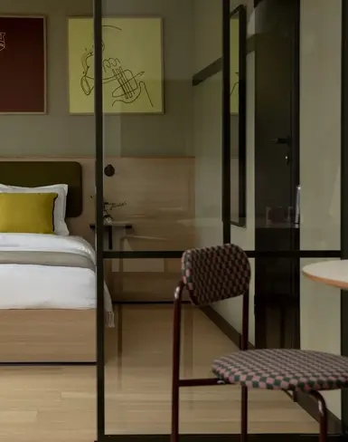 a bed with pillows and a chair in a room