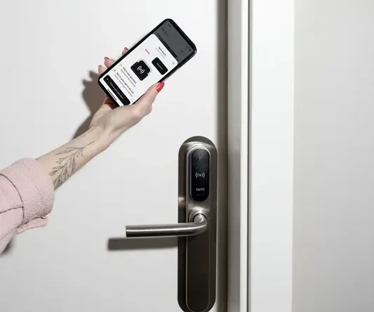 a hand holding a phone next to a door handle