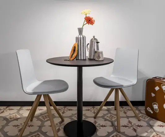 a table with chairs and a vase of flowers