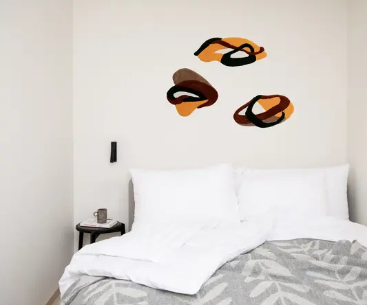 a bed with pillows and a coffee cup on the side