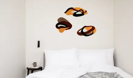 a bed with pillows and a coffee cup on the side