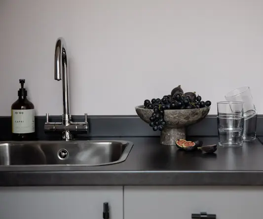 a bowl of grapes on a counter top
