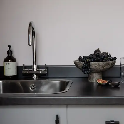 a bowl of grapes on a counter top