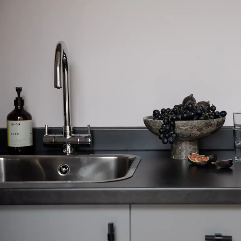a bowl of grapes on a counter top