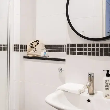a bathroom with a round mirror and a sink