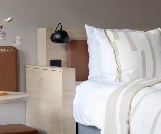 a bed with pillows and a lamp