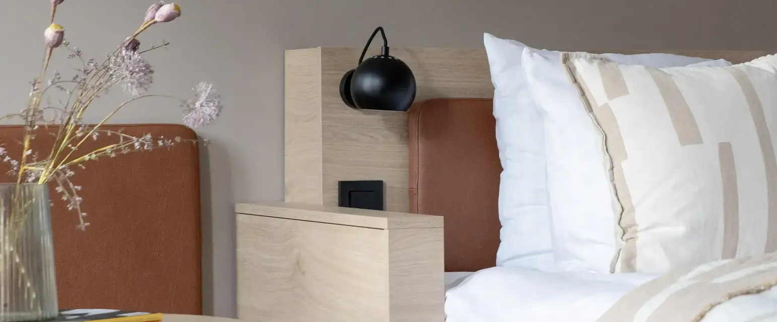 a bed with pillows and a lamp