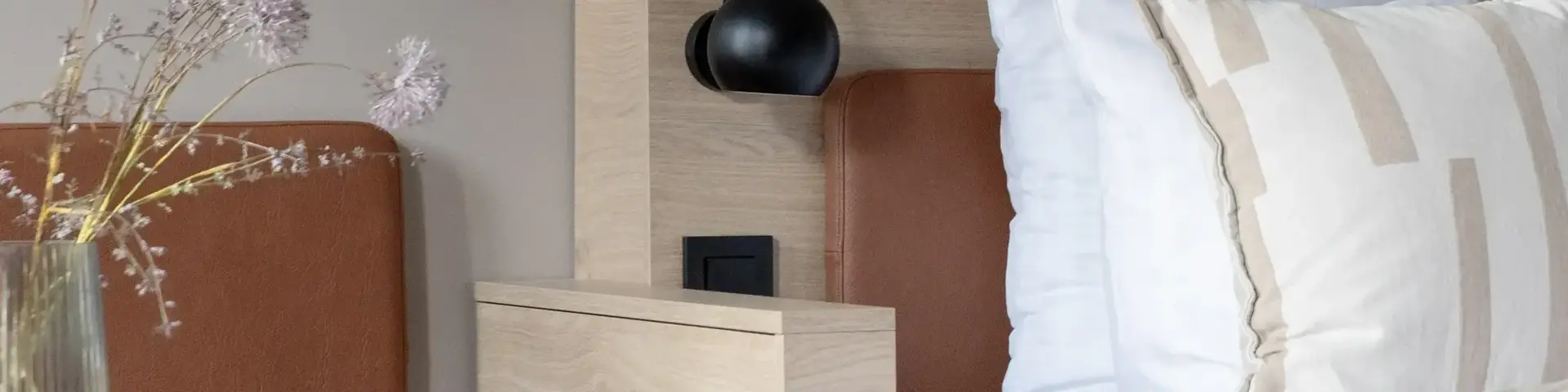 a bed with pillows and a lamp