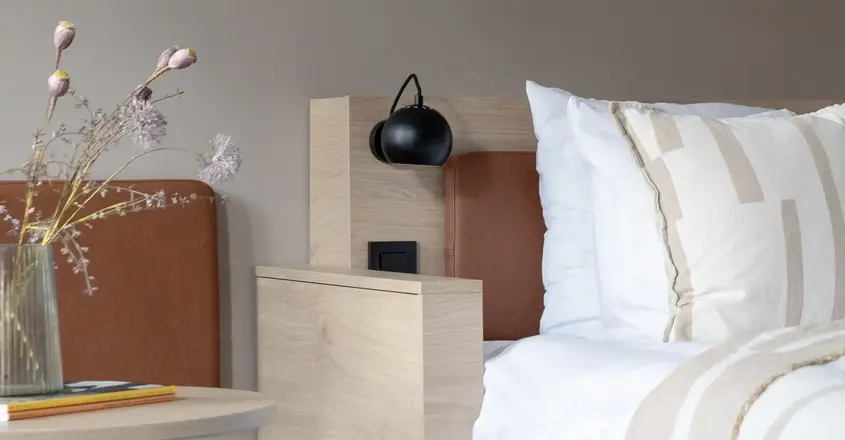 a bed with pillows and a lamp