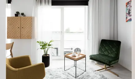 a room with a green chair and a coffee table