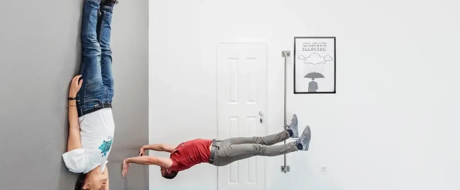 a man and woman upside down on a wall