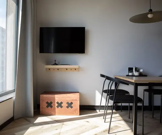 a room with a table and a tv on the wall
