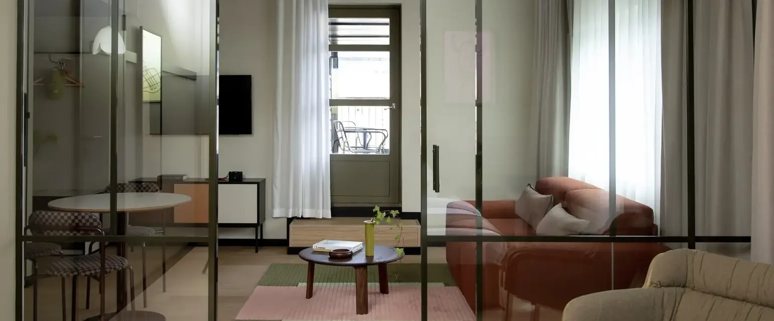 a glass door with a couch and a table in front of it